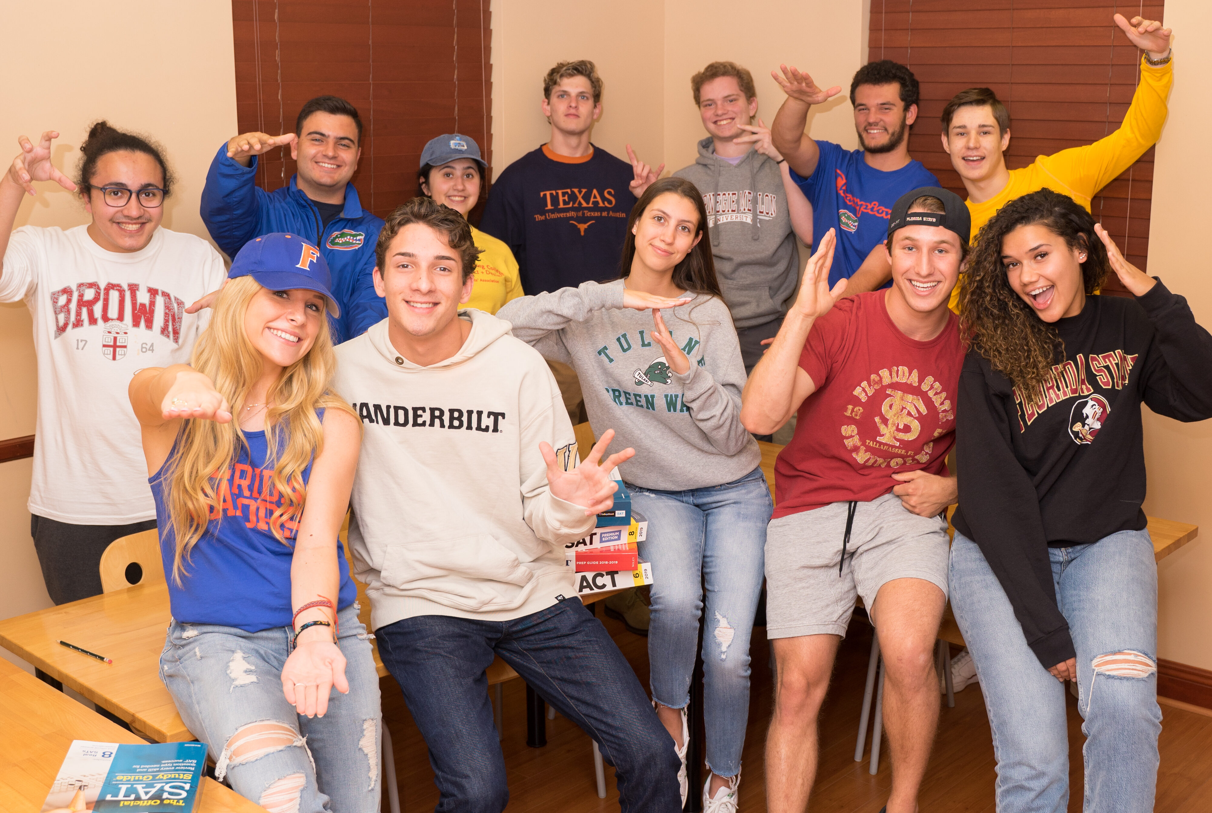 Group of high school seniors wearing the gear from the colleges that they were admitted to