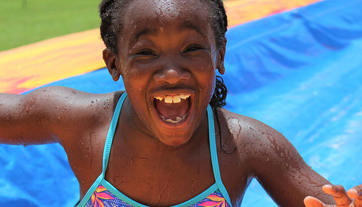 girl with big smile on her face going down waterslide