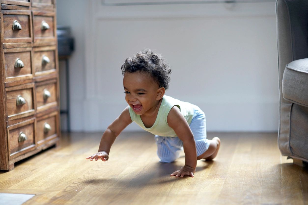 child crawling on floor happily